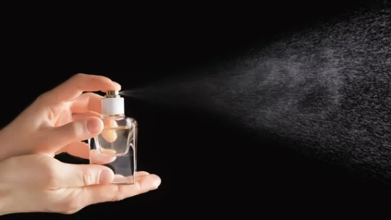 Person spraying perfume
