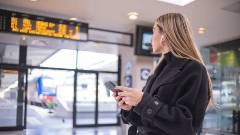woman holding phone checking train timings