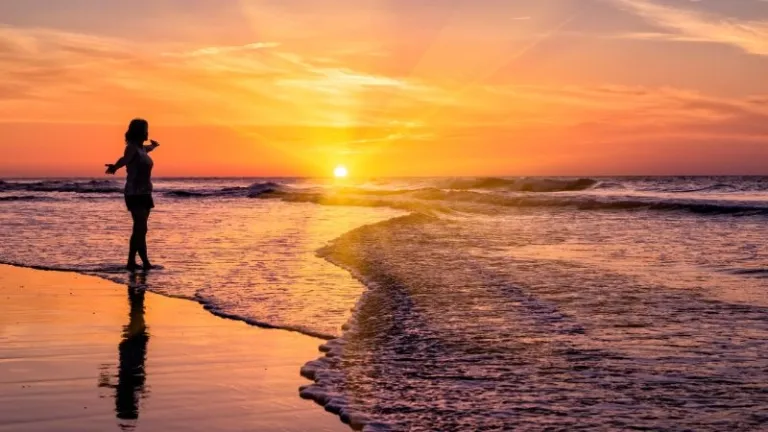 woman walking the beach at sunrise