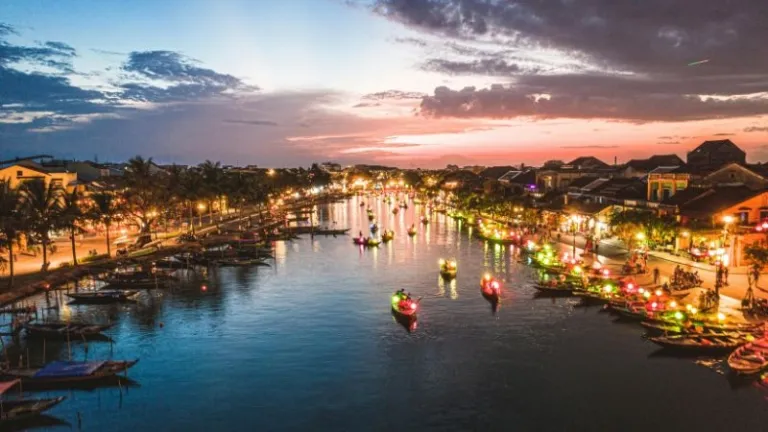boats travelling down a river in hoi an