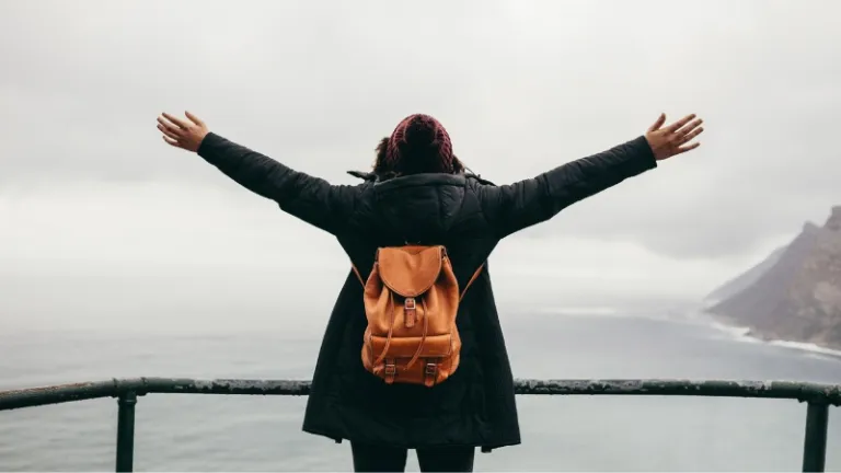 arms spread wide overlooking the sea