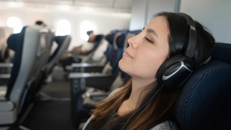 woman on an airplane lounging with headphones on