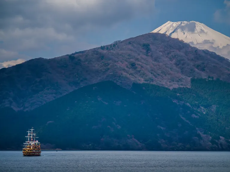 Hakone pirate sightseeing cruise ship on Lake Ashi with Mount Fuji beyond forested hills, Kanagawa, Japan
