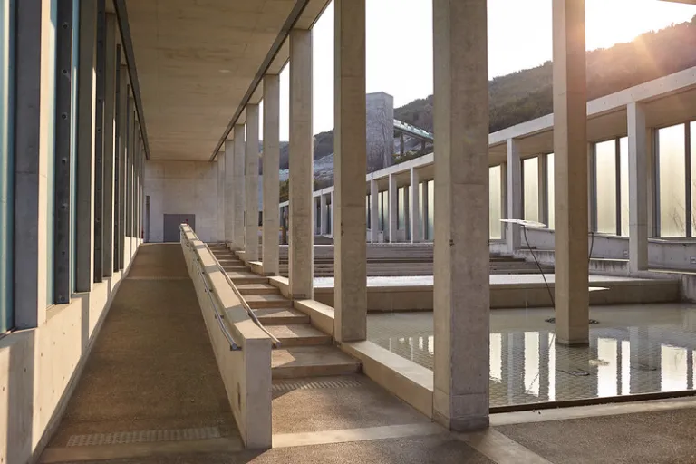 Walkway at Awaji Yumebutai, featuring Tadao Ando's exposed concrete architecture, reflecting pools, and natural light.