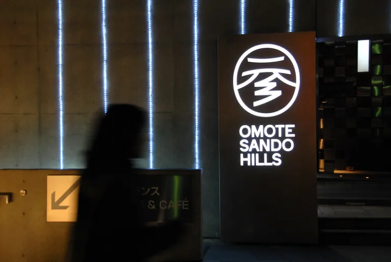 Illuminated Omotesando Hills sign outside the shopping complex designed by Tadao Ando in Tokyo.