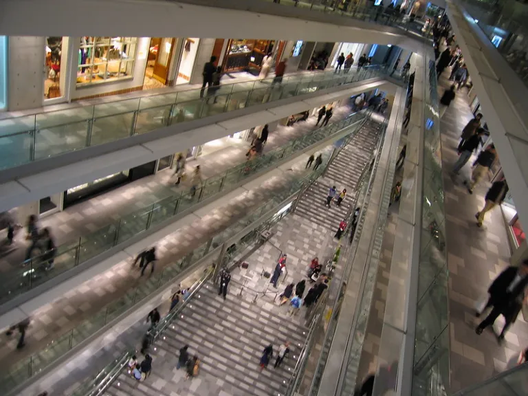 Interior of Omotesando Hills, designed by Tadao Ando with multi-level walkways, open atrium, and minimalist architecture.