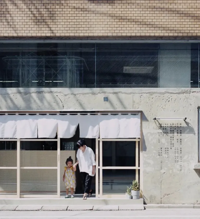 Exterior of Koganeyu, a renovated sento in Sumida, Tokyo, with visitors standing by the entrance.