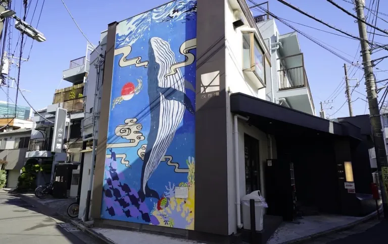 Exterior of Kairyou-yu in Shibuya, Tokyo, featuring a large blue whale mural on the side of the building.
