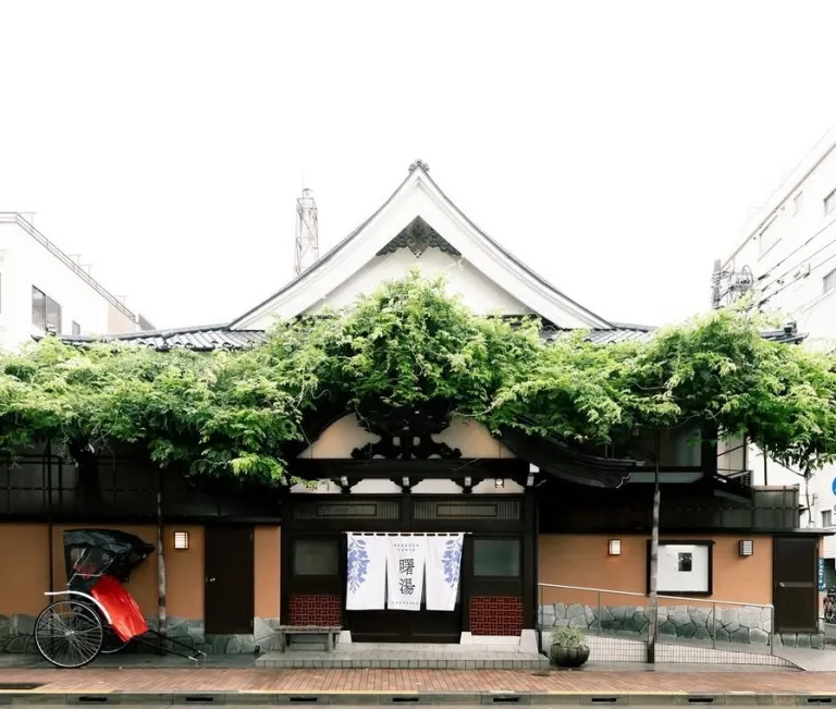 Exterior of Akebonoyu, a historic sento in Asakusa, Tokyo, with greenery covering its traditional entrance.
