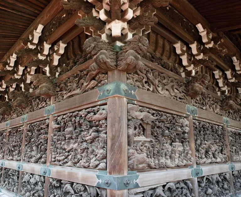Intricate wooden carvings on the exterior of Shibamata Taishakuten Temple, showcasing detailed Buddhist temple craftsmanship.