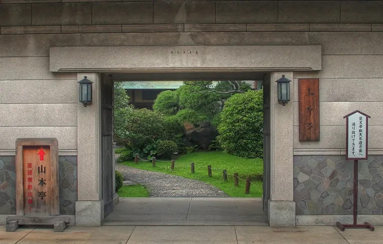 Entrance to Yamamoto-Tei in Shibamata, with a stone gate opening onto a peaceful Japanese garden.