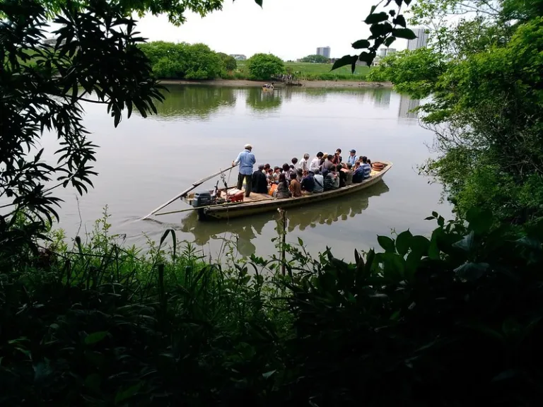 Traditional Yagiri-no-Watashi ferry carrying passengers across the Edo River, surrounded by lush riverside greenery in Shibamata.