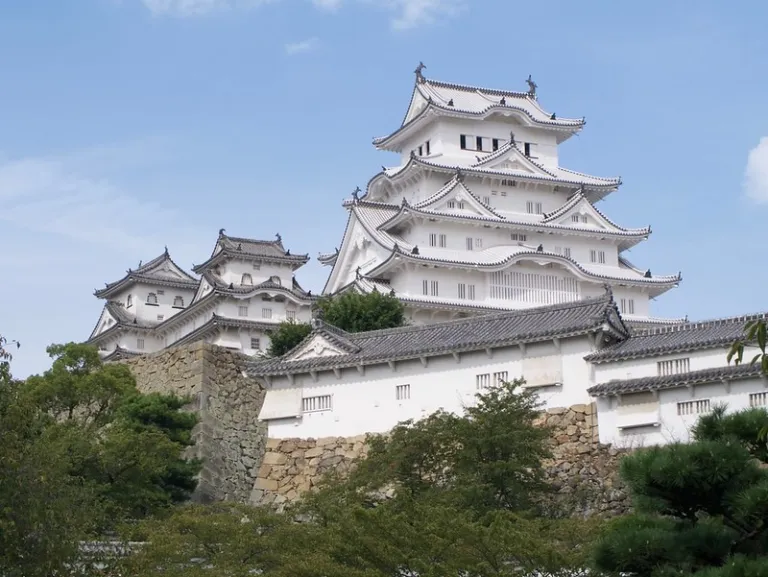 Exterior view of Himeji Castle with its iconic white plaster walls under a clear blue sky