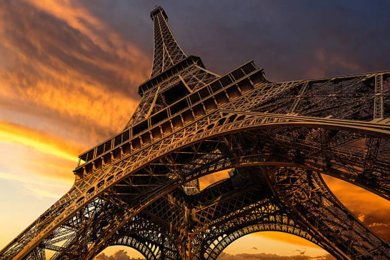 Dramatic sunset paints the Eiffel Tower in golden hues.